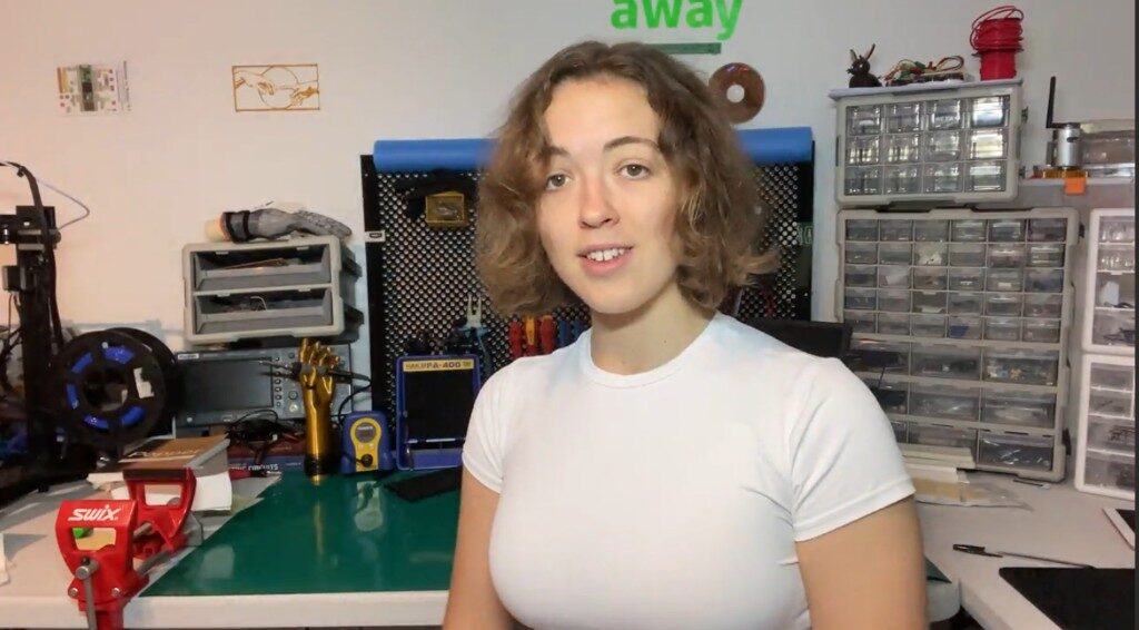 Freesia at a workbench with tools, parts drawers, and a 3D printer