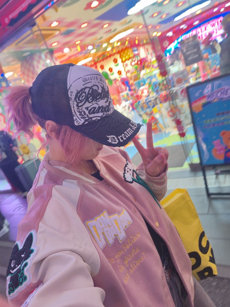 Freesia in a pink jacket and cap, peace sign, in a bright arcade