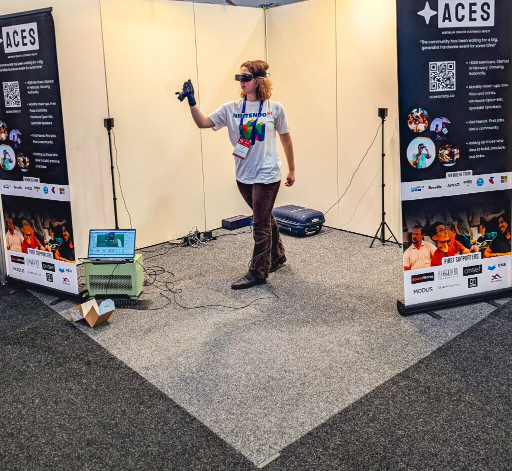 A headset and glove demo between two ACES banners